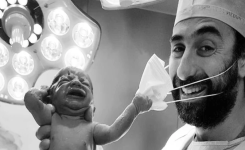 Cette photo d'un nouveau-né tirant le masque d'un médecin fait le tour du monde et devient un symbole d'espoir
